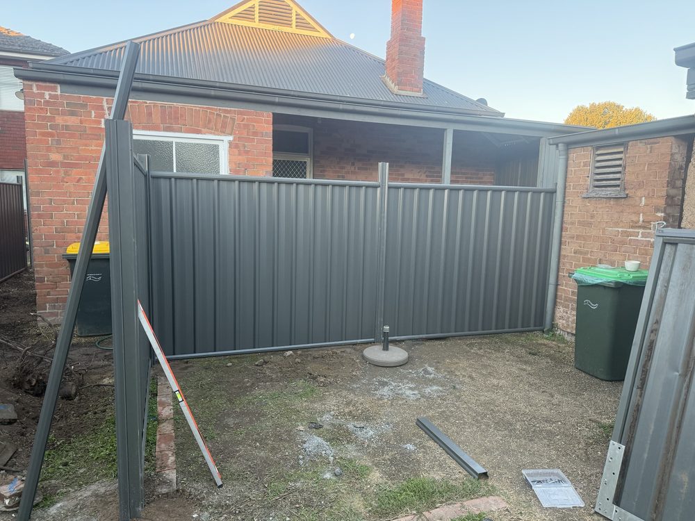 Colorbond fence installed behind a brick home